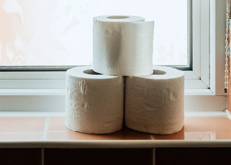 Drei Toilettenpapierrollen auf einer Fensterbank